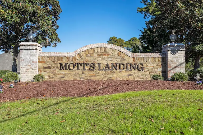 Mott's Landing community entrance sign brick with brown text lettering
